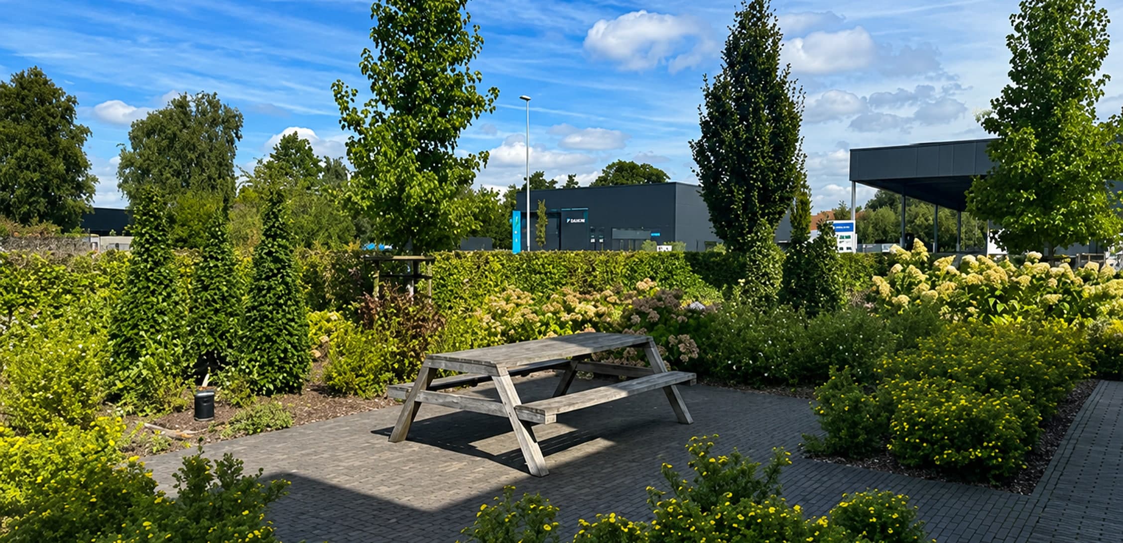Aangelegde tuin met picknicktafel, beplanting en verharding